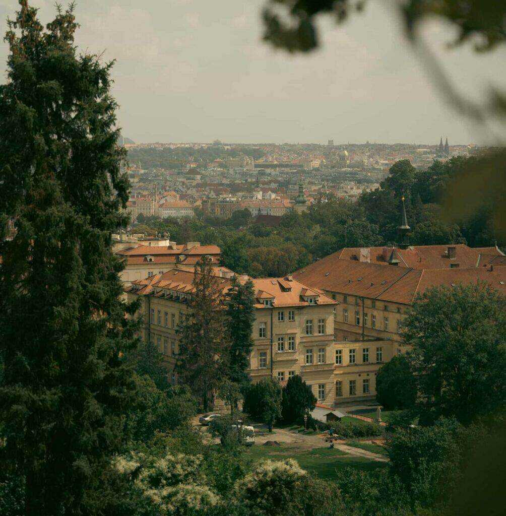 Pohled na město s dominantou kostela, zasazený do zeleně a okolní přírody, vyjadřující propojení historické a moderní architektury s krajinou. Tento pohled ilustruje klíčový aspekt územně analytických podkladů – zajištění udržitelného rozvoje měst a ochrany přírodních a kulturních hodnot při plánování infrastruktury a občanské vybavenosti.